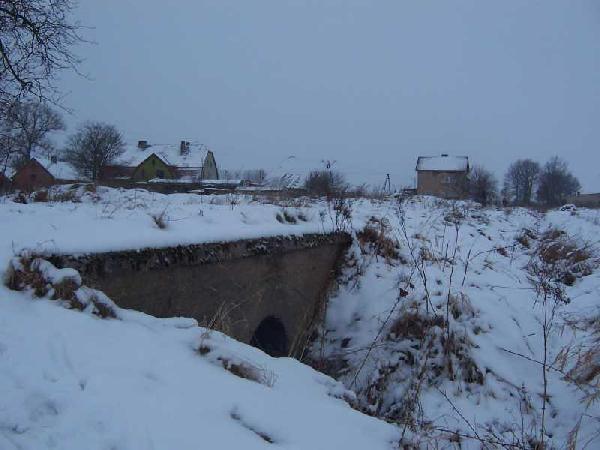 Przepust pod nasypem, na drugim planie widoczny budynek dworca kolejowego. Stan 15 II 2009, fot. LAX.W.Stopka, ze strony www.kolej.one.pl
